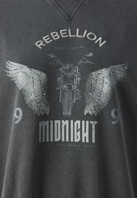 Gray T-shirt featuring a motorcycle graphic with wings, embellished with rhinestones. Includes text: "REBELLION" and "MIDNIGHT."