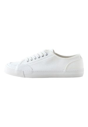 Hvid lavtop lærredsneaker med hvide snørebånd og gummisål, vist fra siden på en hvid baggrund.