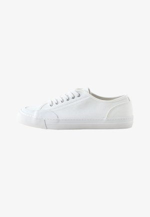 Hvid lavtop lærredsneaker med hvide snørebånd og gummisål, vist fra siden på en hvid baggrund.