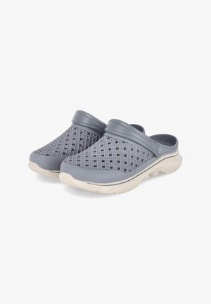 Grau geformte Clogs mit einem strukturierten Rippendesign, abgerundeten Kanten und einer kontrastierenden weißen Sohle. Offene Rückseite für einfaches Anziehen und Luftzirkulation.