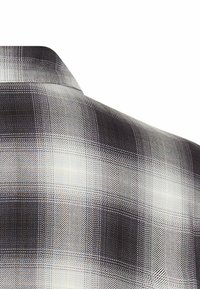 Kurzärmeliges Hemd mit einem schwarz-weißen Karomuster, glatter Textur und dezentem Glanz. Rückansicht zeigt Details des Kragens.