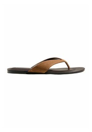 Brown suede thong sandal with flat black sole and wide strap over foot, shown in side profile on white background.