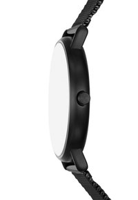 Montre noire avec un boîtier ovale et un cadran blanc minimaliste. Elle présente un bracelet noir texturé et un bouton latéral proéminent.