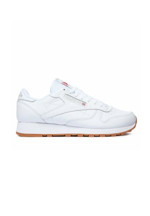 Biały skórzany sneaker Reebok Classic z gumową podeszwą, sznurowaniem z przodu oraz logo brytyjskiej flagi na bocznej części i języku.