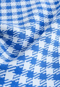 Tessuto a maglia con motivo pied de poule blu e bianco, con una texture liscia e un peso medio. Il design mette in evidenza colori e forme alternate.