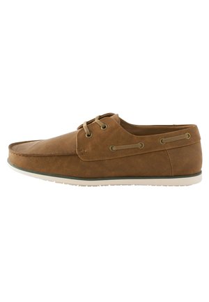 Zapato de barco de cuero marrón con punta redondeada, dos ojales para los cordones y suela de goma blanca. Presenta un acabado texturizado y cordones en tono marrón claro.