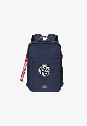 Sac à dos en nylon bleu marine avec un grand logo circulaire, des compartiments zippés et une étiquette rouge indiquant "Taille cabine d'avion". Il dispose de bretelles rembourrées.