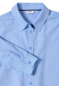 Jasnoniebieska koszula na guziki wykonana z teksturowanej tkaniny, z klasycznym kołnierzykiem, posiadająca pasujące niebieskie guziki oraz metkę z napisem "CECIL".