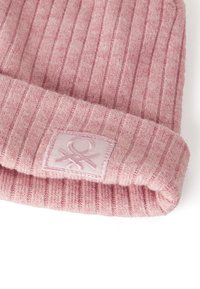 Różowa prążkowana czapka beanie wykonana z miękkiej dzianiny, z podwiniętym brzegiem i kwadratową naszywką z logo z przeszyciami.