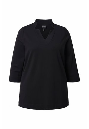 Tunica nera con scollo a V e maniche a tre quarti. Realizzata in tessuto morbido con una texture liscia. Include un dettaglio sottile di cuciture laterali.