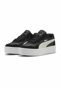 Crne tenisice s bijelim potplatom, od antilopa i sintetičkog materijala, sa bijelim PUMA prugom i logotipom. Niska dizajna s ravnim vezicama.