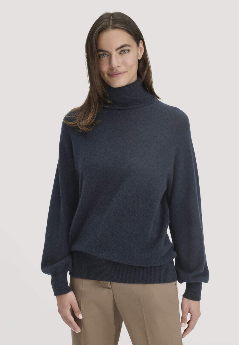 Navyblauer Rollkragenpullover aus weichem Stoff, mit lockerer Passform, abfallenden Schultern sowie gerippten Bündchen und Saum.
