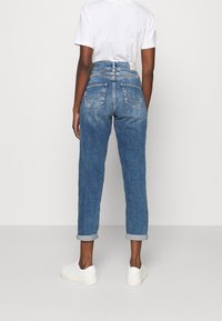 Ljusblå denimjeans med avslappnad passform, med upprullade fållar, två bakfickor och hög midja.