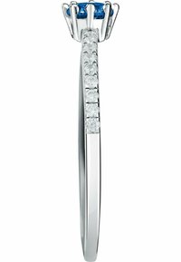 Silver ring med en rund blå sten omgiven av en kroninställning, med en rad små klara stenar längs banden.