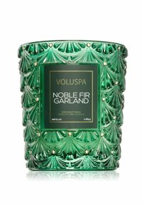 Grön glasljushållare med en strukturerad bladmönster och guldaccenter. Etiketten visar "Voluspa Noble Fir Garland" med specifikationer för kokosvax.
