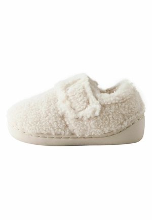Weicher, cremefarbener Fleece-Hausschuh mit Klettverschluss und dicker, gepolsterter Sohle, für den Innenbereich entwickelt.