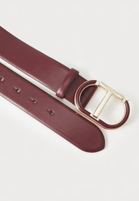 Burgundy leather belt with a gold and maroon round buckle, featuring five holes for adjustment and smooth texture.