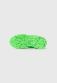 Grønn sneakersåle med teksturert grep, med flamme mønstre og dristig skrift. Laget av gummi, designet for trekkraft og stabilitet.