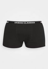 Čierne boxerky vyrobené z mäkkého, elastického materiálu s bielym logom "URBAN CLASSICS" na páske. Obsahujú predný dizajn s vreckom.