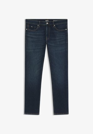 Ciemnoniebieskie dżinsy z denimu o wąskim kroju. Posiadają pięć kieszeni, pomarańczowe przeszycia oraz małą metkę z logo z przodu.