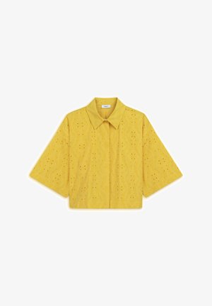 Camisa amarilla recortada con cuello, que presenta patrones de corte floral, mangas cortas y una textura suave. Diseñada para un ajuste relajado.