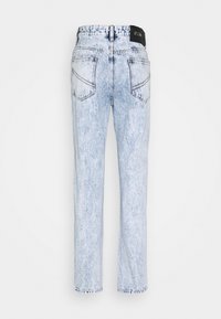 Vaqueros de mezclilla lavado claro con corte recto, que cuentan con dos bolsillos traseros y una etiqueta negra de la marca en la cinturilla. Detalles de textura desgastada.