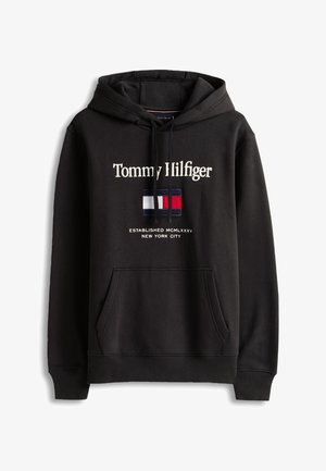 Svart hettegenser med "Tommy Hilfiger" brodert i hvitt, med logo-patch i rødt, hvitt og blått. Inkluderer kengurulomme og snorer.