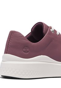 Baskets en cuir violet avec semelle blanche texturée, lacets blancs et logo arbre embossé près du talon.