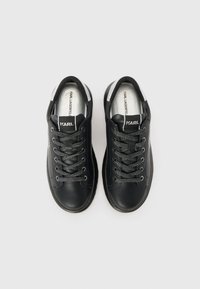 Black leather sneakers with textured laces, silver accents on the heel, and a padded collar. Logo visible on the tongue.
