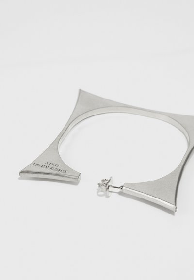 Sølvmetall øreringer med geometrisk design, med en bred trekantet form og en post-åpen lukking. Glatt tekstur og minimal detaljering.