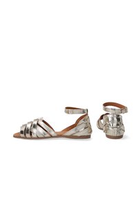 Metalen zilveren platte sandalen met een crisscross strap design, sluiting met een enkelgesp en een gestructureerde leren afwerking.