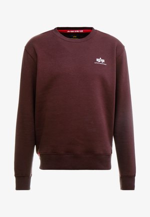 Burgunderfarget genser laget av glatt stoff, med rund hals, lange ermer, og en liten hvit logo på brystet.