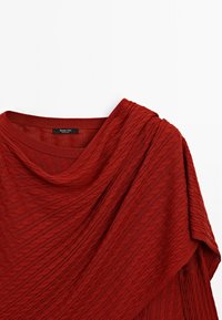 Roestvrij rode kabelgebreide trui met ronde hals en geribbelde kraag, gemaakt door Massimo Dutti, weergegeven op een witte achtergrond.