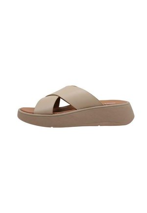 Sandale à semelle compensée avec lanières croisées beige, un dessus texturé, une semelle légèrement surélevée et une doublure intérieure lisse.
