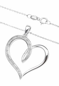 Strieborný prívesok v tvare srdca s lešteným povrchom, ozdobený trblietavým radom malých kameňov pozdĺž obrysu, pripevnený na jemnom reťazci.