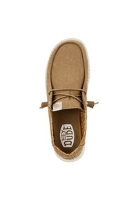 Scarpa slip-on di tessuto color sabbia con superficie testurizzata, punta rotonda, suola crema e un logo nella soletta. Presenta un dettaglio in pizzo decorativo.