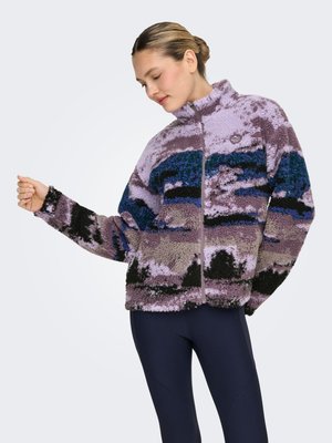 Fleeces jaka ar teksturētu dizainu purpura, melnā un zilā krāsā, kas atgādina kalnu ainavu. Augsts apkakle un rāvējslēdzēja aizdare.