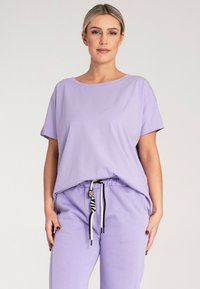 Krótki rękaw z topem lawendowym oraz dopasowanymi spodniami. Miękka tkanina, luźny krój, elastyczny pas z paskiem do regulacji w paski, minimalne detale szwowe.