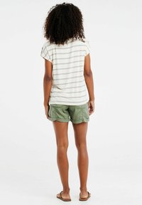 Chemise à manches courtes rayée dans des couleurs claires avec des rayures horizontales violettes, associée à un short olive avec des poches latérales et un ourlet festonné.