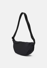 Borsa a spalla nera in nylon con forma arrotondata, chiusura con zip e tracolla regolabile con branding impresso. Texture liscia e design minimale.