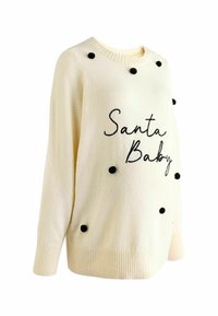 Suéter color crema con puños y dobladillo acanalados, que presenta detalles en pom-pom negros y el texto bordado "Santa Baby".