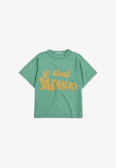 T-shirt vert à manches courtes avec texte jaune "All about Monsters" et petit logo "Bobo Choses" au centre avant.