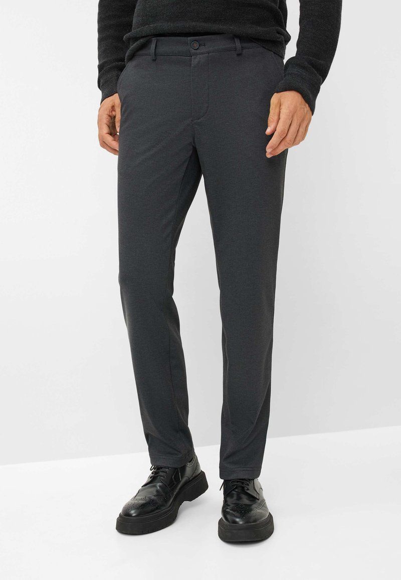 Donkergrijze op maat gemaakte broek met een gladde textuur, platte voorkant en subtiel patroon, gecombineerd met zwarte veterschoenen.