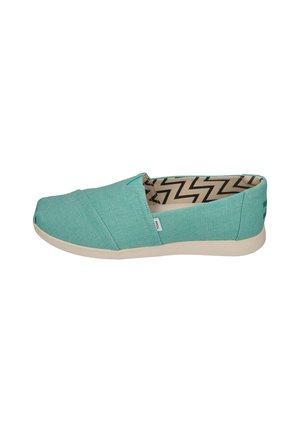 Turquoise canvas slip-on shoes with a textured finish, featuring a rubber sole and zigzag patterned interior lining.