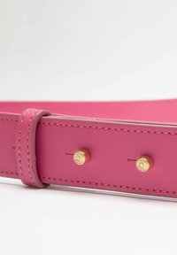 Cintura in pelle rosa con hardware in tonalità oro, cuciture in vista e una texture liscia. Caratterizzata da borchie e un design minimalista.