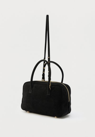 Μαύρη ορθογώνια γυναικεία τσάντα με διπλές χερούκλες στην κορυφή, ρυθμιζόμενο ιμάντα ώμου, χρυστό φερμουάρ και μικρά χρυσά ποδαράκια σε λευκό φόντο.