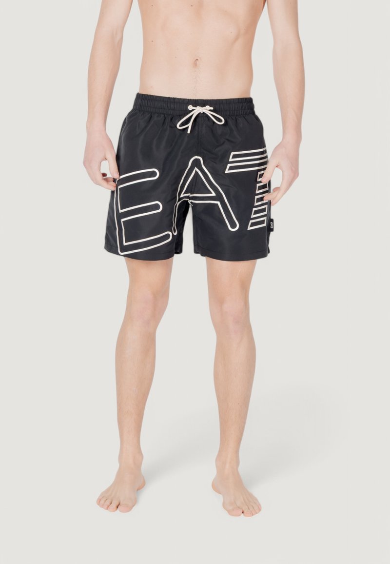 Bañador negro con cintura ajustable, que presenta grandes letras blancas que dicen "EAT" y delgadas rayas blancas en un lado. Textura suave.