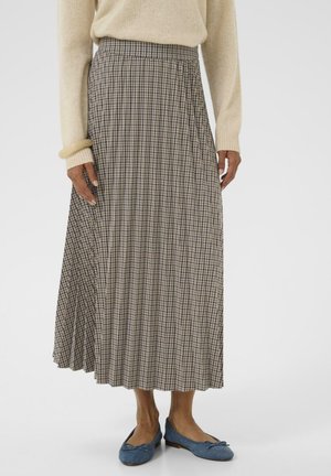 Pleated maxi skirt in brown and cream check pattern, with an elastic waistband and a flowy silhouette, paired with blue ballet flats.