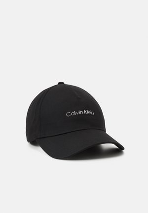 Casquette de baseball noire avec une visière incurvée et "Calvin Klein" brodé en blanc au centre avant.