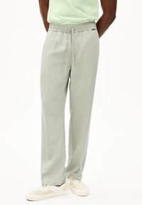 Lichtgroene, geweven broek met een elastische tailleband en trekkoord. Heeft voorplooien, zijzakken en een comfortabele pasvorm.